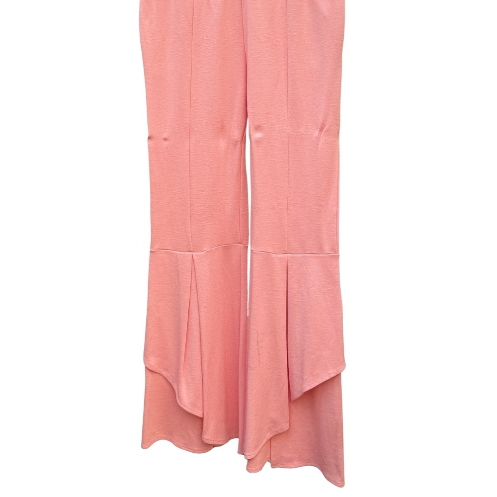 pair of pink bell bottom pants with an asymmetrical ruffle hem